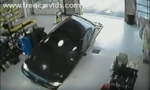 Car drives directly into mechanics pit