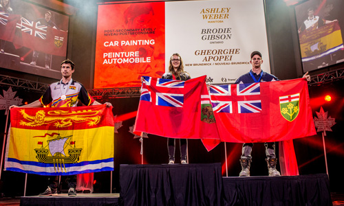 Ashley Weber (middle) winning Gold in the post-secondary level of car painting, at the WorldSkills competition in 2016. To her right is Brodie Gibson, winning Silver, and to her left is Gheorghe Apopei, winning Bronze.